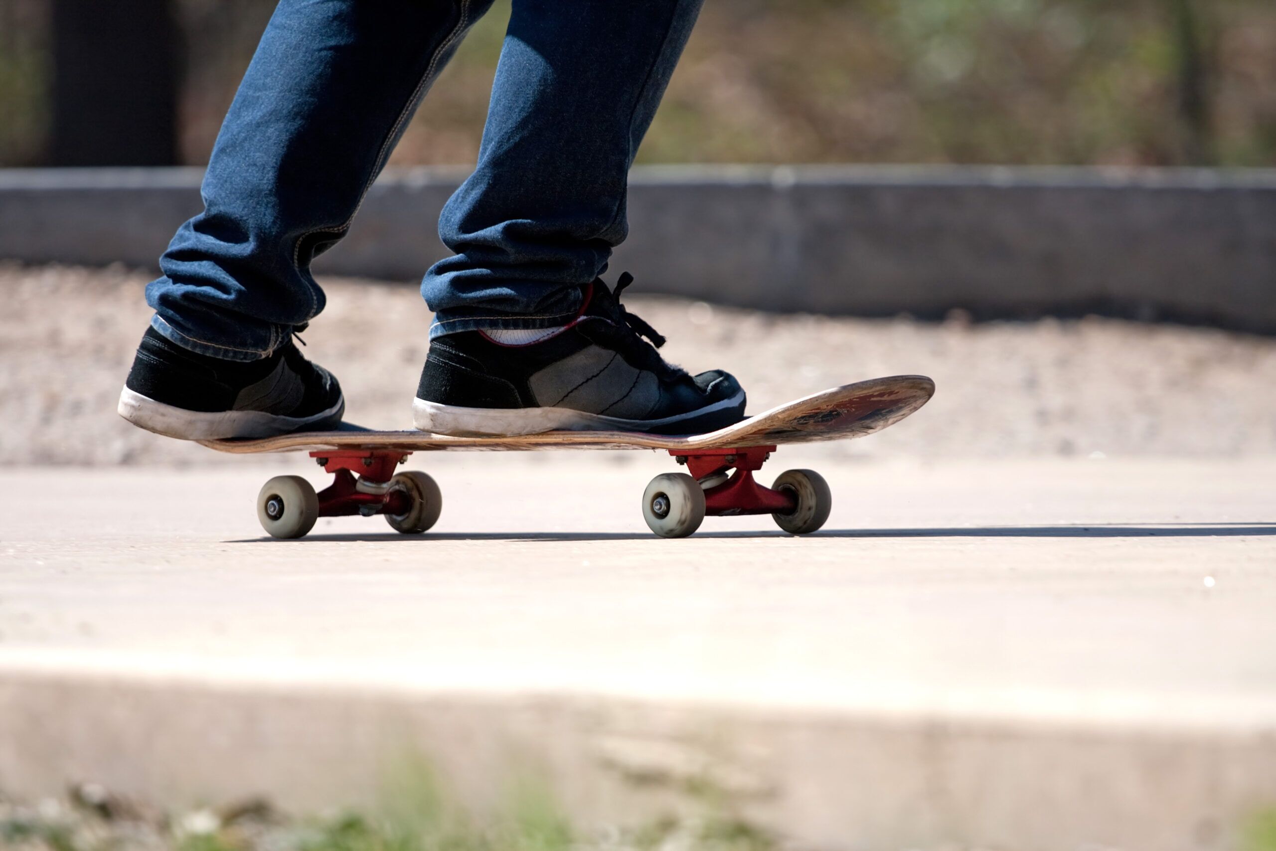 close up of a skateboarders feet while skating on concrete at the skate park SBI 301045813